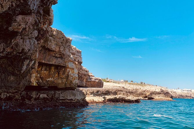 Boat tour of the Polignano a Mare caves with aperitif - Scoglio dell’Eremita: Legend, Cholera, and an Iron Cross